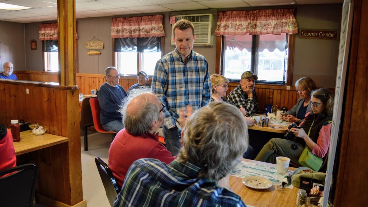 Congressman Jared Golden talking to people at a restaurant.