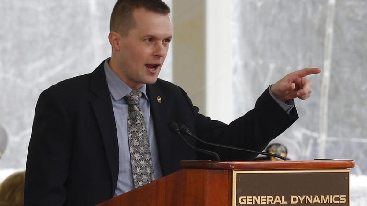Jared Golden speaks at a podium at BIW (Photo Credit: David Sharp/Associated Press)