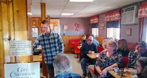 Congressman Jared Golden talking to people in a restaurant.