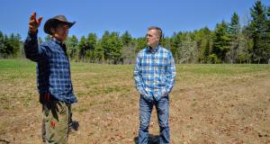 Congressman Golden speaks with a constituent in a field.