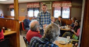 Congressman Jared Golden talking to people at a restaurant.