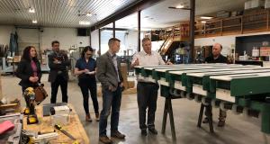 Congressman Jared Golden examining equipment with crowd.