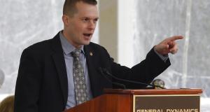 Jared Golden speaks at a podium at BIW (Photo Credit: David Sharp/Associated Press)