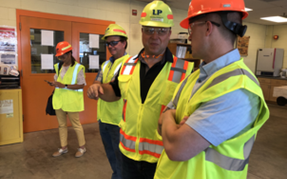 JG in hard hat with workers.