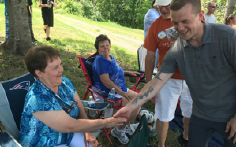 Congressman Jared Golden shaking a woman's hand.