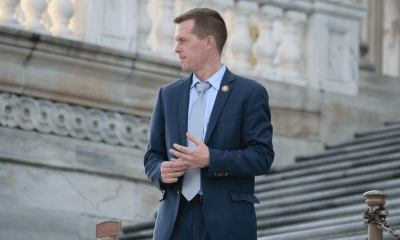 Congressman Jared Golden of Maine standing on the steps of the U.S. Capitol, wearing a blue suit. 