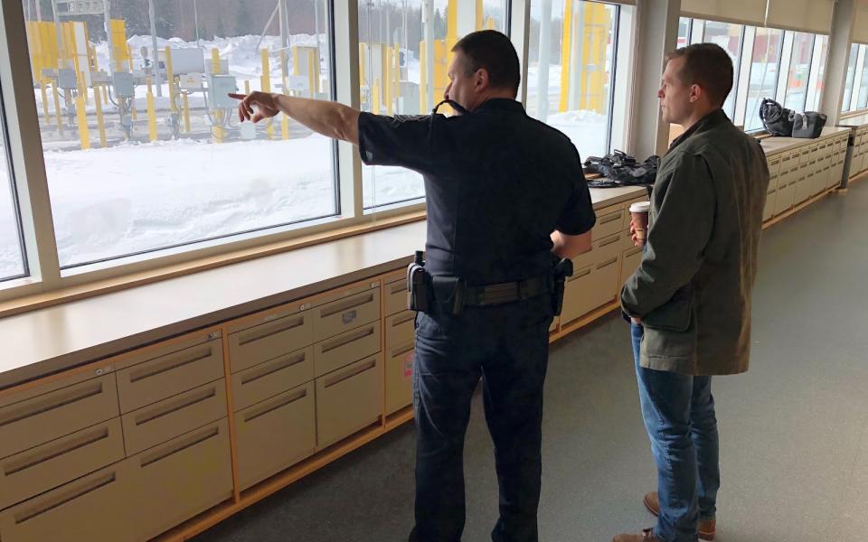 Congressman Jared Golden looks out the window with another gentleman.