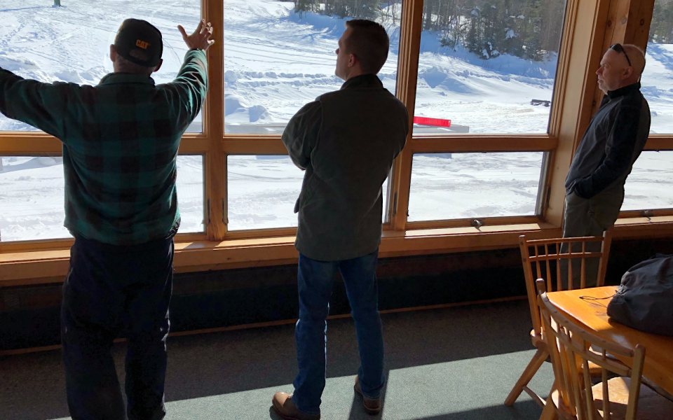 Congressman Jared Golden looks out a window with constituents.