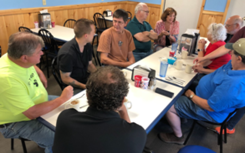 Congressman Jared Golden speaks with people at a restaurant.