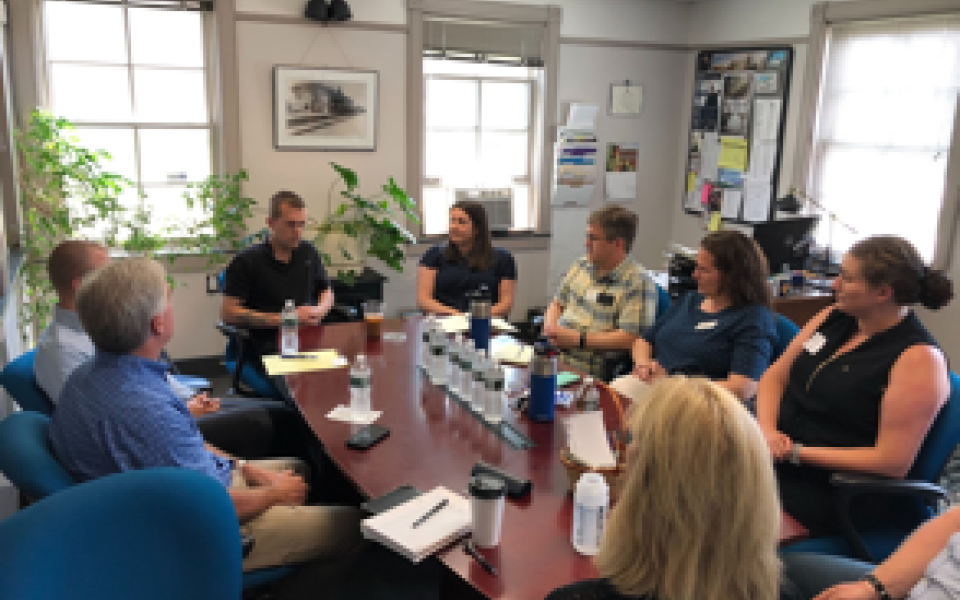 Congressman Jared Golden talking at a table with people.