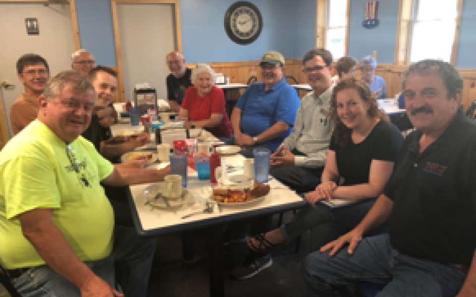 Congressman Jared Golden smiles with people at a restaurant.