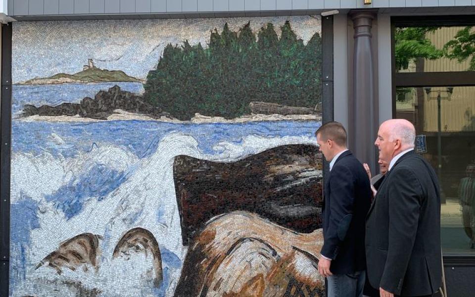 Congressman Golden looking at a mosaic.